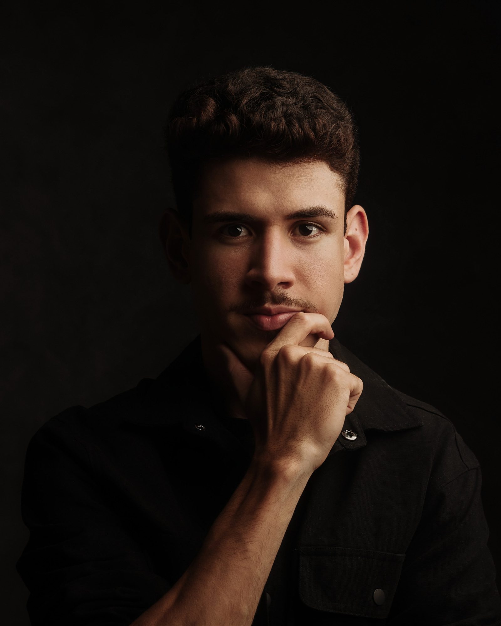 Gabriel Araújo, barbeiro e visagista da SHARP, em retrato com fundo escuro