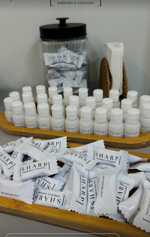 Frascos pequenos e balas embaladas com a marca SHARP Barbearia & Visagismo